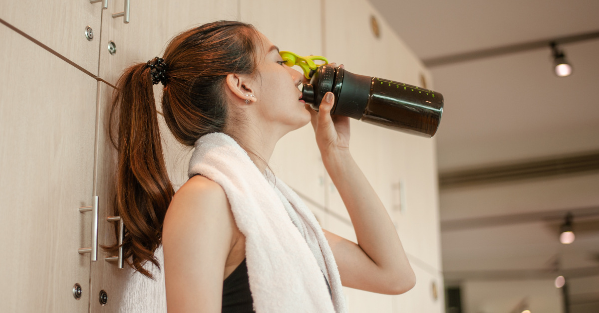 Image of a woman drinking a protein shake, related to the variety of healthy protein supplements women can benefit from.